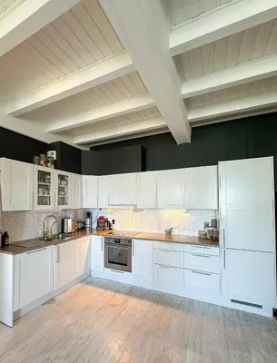 a large white kitchen with white cabinets and appliances at Modern and spacious home in Trondheim