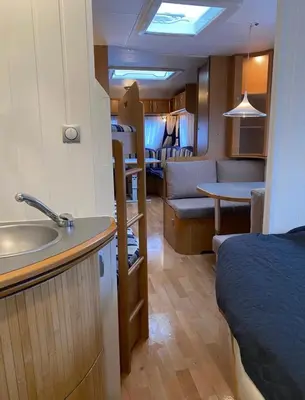 a kitchen and a living room with a sink and a room at Aurora Caravan Near Bergen in Strusshamn