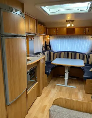 a small kitchen with a table and a small table at Aurora Caravan Near Bergen in Strusshamn