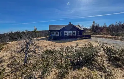 a small blue house on a hill in a field at Cozy Home In Ulnes With Sauna in Ulnes