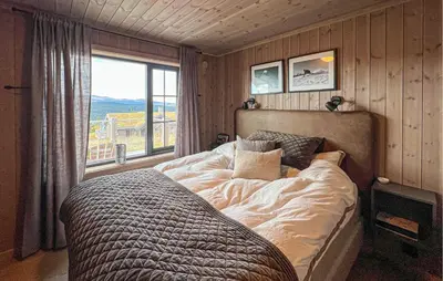 a bedroom with a large bed with a large window at Amazing Home In Gålå With Sauna in Gålå