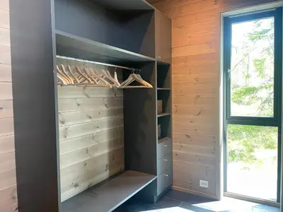 a walk in closet with wooden walls and a window at The Lookout At Beitostølen in Beitostøl