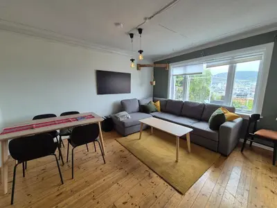 a living room with a couch and a table at 2-roms leilighet med spektakulær utsikt og privat hage in Bergen