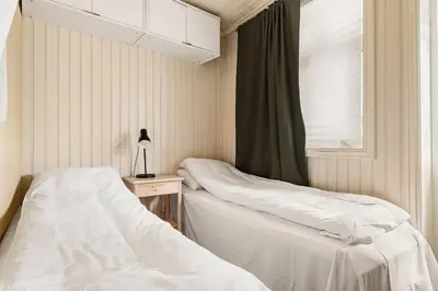two beds in a room with a window at 2-roms leilighet med spektakulær utsikt og privat hage in Bergen