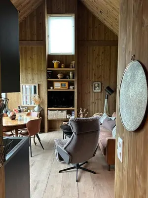 a living room with a chair and a table at Architectural gem with fjord view in Holmedal