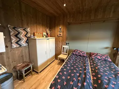 a bedroom with a bed in a wooden room at Architectural gem with fjord view in Holmedal