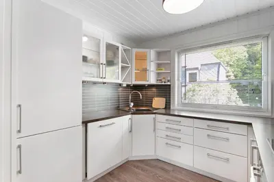 a kitchen with white cabinets and a window at Centrum Apartment in Ålesund