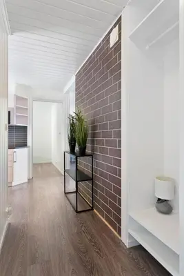 a living room with a brick wall and a table with plants at Centrum Apartment in Ålesund