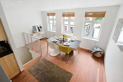 a dining room with a table and yellow chairs at Historic Apartment in the Heart of Bergen in Bergen