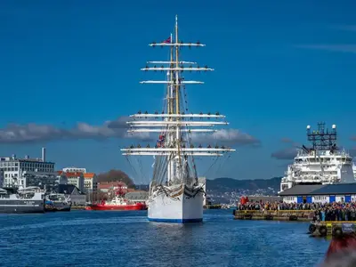 a tall ship in the water with other ships at Historic Apartment in the Heart of Bergen in Bergen