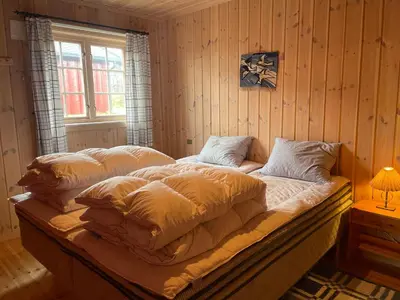 a bed with pillows on it in a room at Koselig Og Sentral Hytte Med Peis Og Badstue in Beitostøl