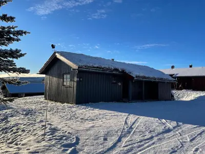 a building with a snow covered roof in the snow at Koselig Og Sentral Hytte Med Peis Og Badstue in Beitostøl