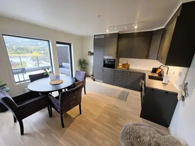 a kitchen and living room with a table and chairs at Nice apartment in the center of Trysil 403 in Trysil