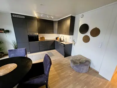 a kitchen with black cabinets and a table and chairs at Nice apartment in the center of Trysil 403 in Trysil