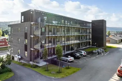 an apartment building with cars parked in a parking lot at Nice apartment in the center of Trysil 402 in Trysil