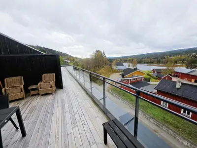 a balcony with two chairs and a view of a river at Nice apartment in the center of Trysil 402 in Trysil