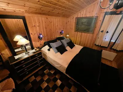 a bedroom with a bed in a wooden room at Cozy Cabin Retreat in Trysil, Norway for Families in Trysil