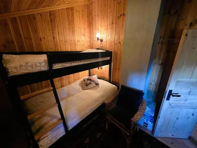 a bedroom with two bunk beds and a chair at Cozy Cabin Retreat in Trysil, Norway for Families in Trysil
