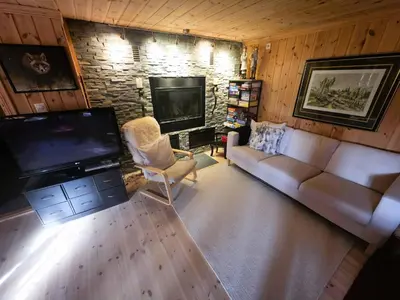 a living room with a couch and a flat screen tv at Cozy Cabin Retreat in Trysil, Norway for Families in Trysil