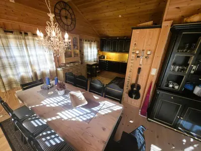 a dining room with a wooden table and a chandelier at Cozy Cabin Retreat in Trysil, Norway for Families in Trysil