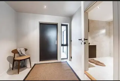a hallway with a black door and a chair at New house in the center of Trysil in Trysil
