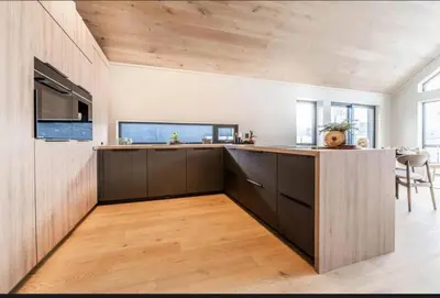 an open kitchen with wooden cabinets and a wooden floor at New house in the center of Trysil 2 in Trysil