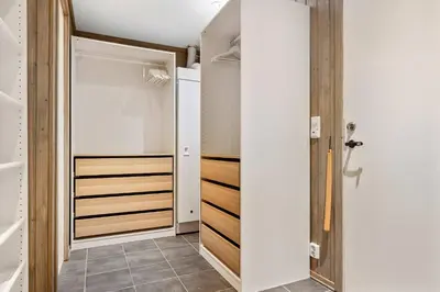 a walk in closet with white walls and wooden shelves at Fageråsen 963 by Vacation Trysil in Trysil