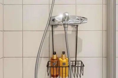 a shower filler in a bathroom with two bottles at Fageråsen 963 by Vacation Trysil in Trysil