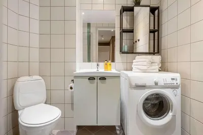a bathroom with a toilet and a washing machine at Fageråsen 963 by Vacation Trysil in Trysil