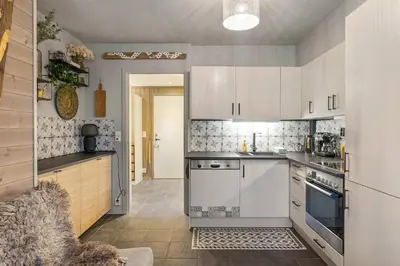 a kitchen with white cabinets and a stove top oven at Fageråsen 963 by Vacation Trysil in Trysil