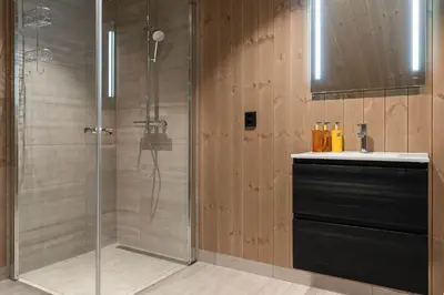 a shower with a glass door next to a sink at Mountain Chalet 958 by Vacation Trysil in Trysil
