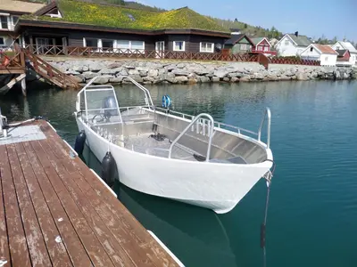 a white boat is docked at a dock at Solstrand Fjord Holiday in Eidsvåg