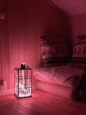 a lit up room with a bed and a lantern at Cozy year-round cabin with sauna at Furutangen in Åmot