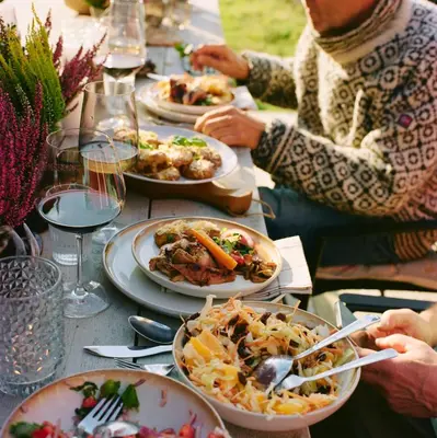 a group of people sitting around a table with plates of food at Kyn Sjøstuer in Stavang