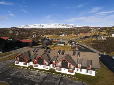 an aerial view of a house with snow covered mountains at Alpine Apartment with Parking and Balcony in Ustaoset