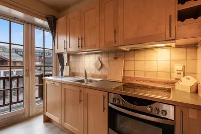 a kitchen with wooden cabinets and a sink and a window at Alpine Apartment with Parking and Balcony in Ustaoset