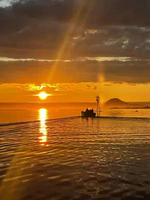 a boat on the beach at sunset with a rainbow at Vár Seaside Cabin in Stavang