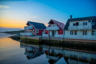 a row of houses on the water at sunset at Eldur Seaside Cabin in Stavang