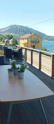 a wooden table with two potted plants on a deck at Renovated Chapel With Fjord Views In Vågstranda in Reistad