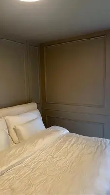 a bed with white sheets and pillows in a room at Stylish home near airport in Bergen