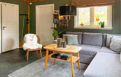 a living room with a couch and a table at 2 Bedroom Cozy Home In Straumgjerde in Brunstad
