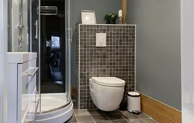 a bathroom with a toilet and a tiled wall at 2 Bedroom Cozy Home In Straumgjerde in Brunstad