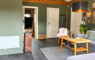 a living room with a couch and a table at 2 Bedroom Cozy Home In Straumgjerde in Brunstad