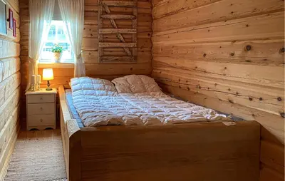 a bed in a room with a wooden wall at 3 Bedroom Beautiful Home In Straumgjerde in Brunstad