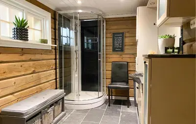 a shower in a room with a bench and a chair at 3 Bedroom Beautiful Home In Straumgjerde in Brunstad