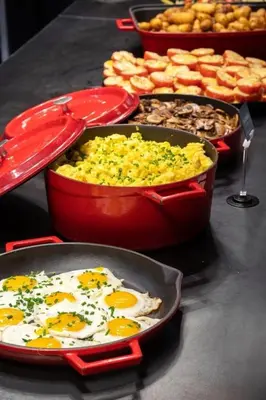 a table topped with pans of eggs and other food at Thon Hotel Verdal in Verdal