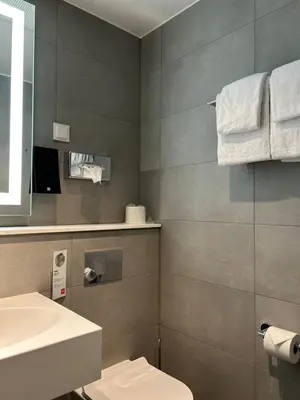 a bathroom with a toilet and a sink and towels at Thon Hotel Verdal in Verdal