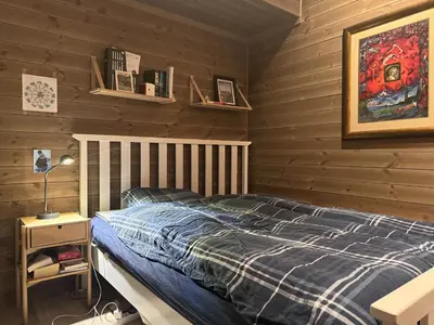 a bedroom with a bed and a wooden wall at Moderne leilighet på Glomsrud Golsfjellet vest in Gol