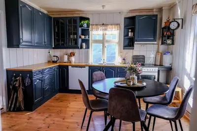 a kitchen with blue cabinets and a table and chairs at Leave It All in Venabygd