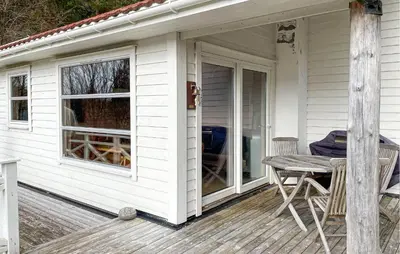 a porch of a white house with a table and chairs at 1 Bedroom Cozy Home In Førde I Hordaland in Erve